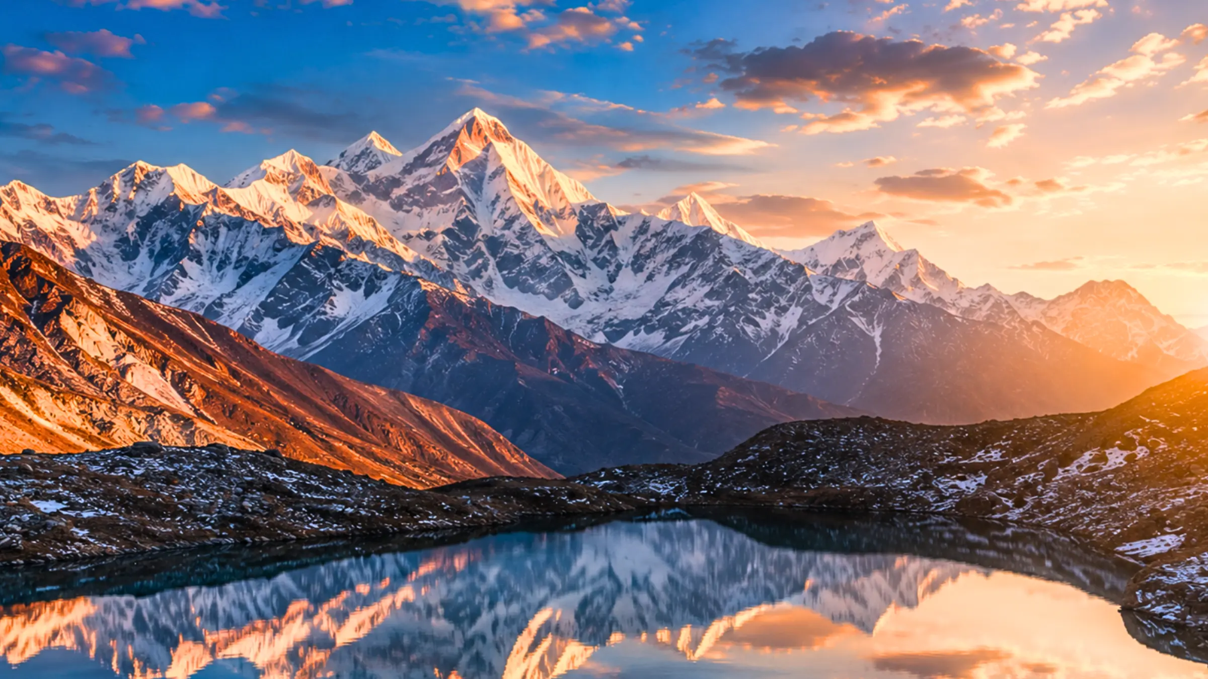 Snow-capped Himalayan peaks reflected in a still lake at dawn